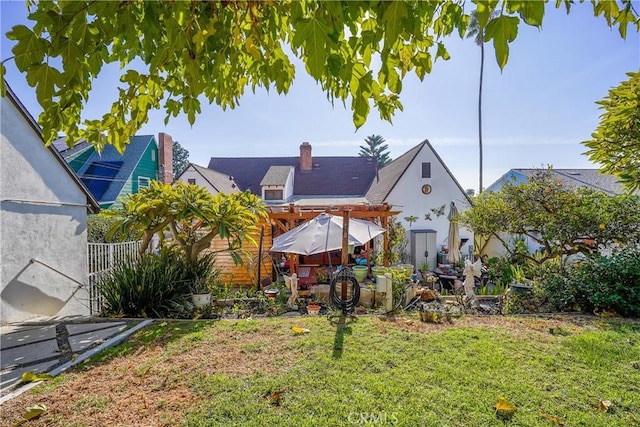 back of house with a yard and a pergola