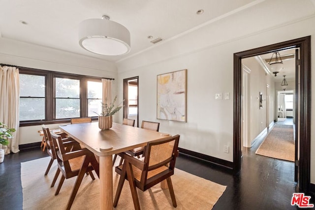 dining room featuring dark hardwood / wood-style flooring and crown molding