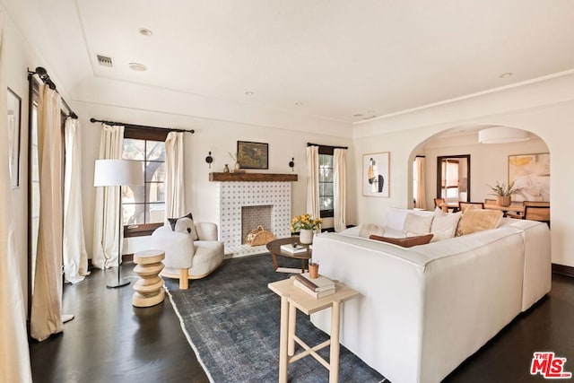 living room with dark hardwood / wood-style floors and a tiled fireplace