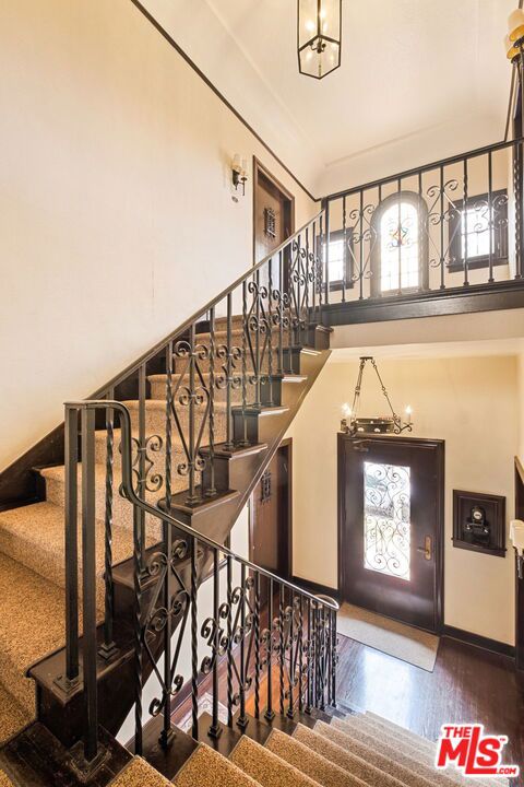 stairway with hardwood / wood-style flooring and an inviting chandelier