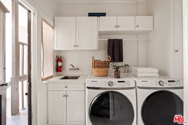 laundry room with cabinets, sink, ornamental molding, and washing machine and dryer