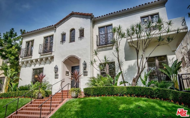 mediterranean / spanish home with a front yard