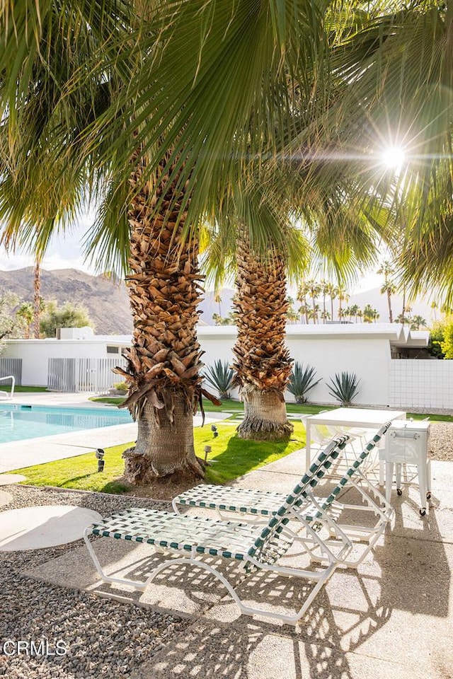 exterior space featuring a mountain view and a fenced in pool