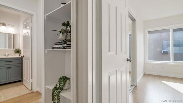 corridor with sink and light hardwood / wood-style floors