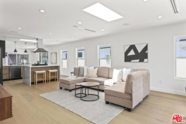 living room featuring a skylight and light hardwood / wood-style floors