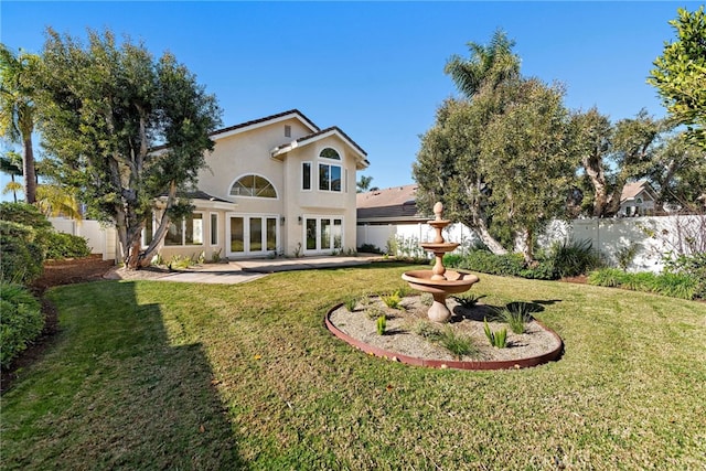 back of house featuring a lawn and french doors