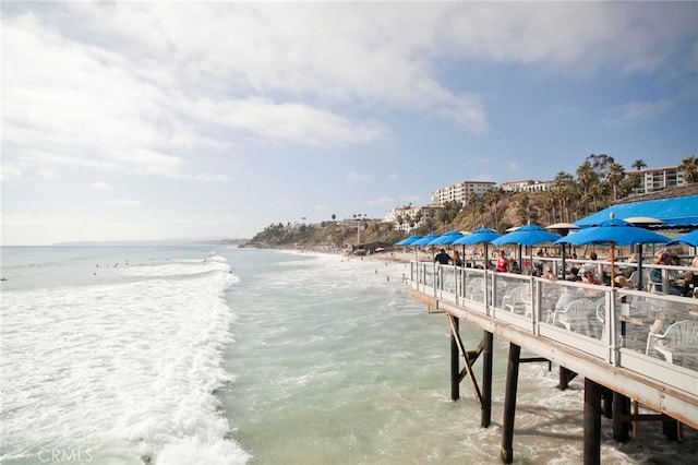 dock area with a water view and a beach view