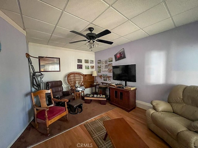 living room featuring a drop ceiling, hardwood / wood-style floors, and ceiling fan