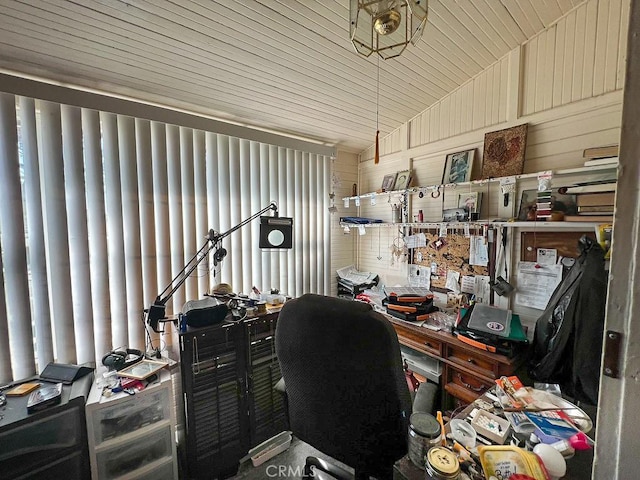 office area with lofted ceiling and wood walls