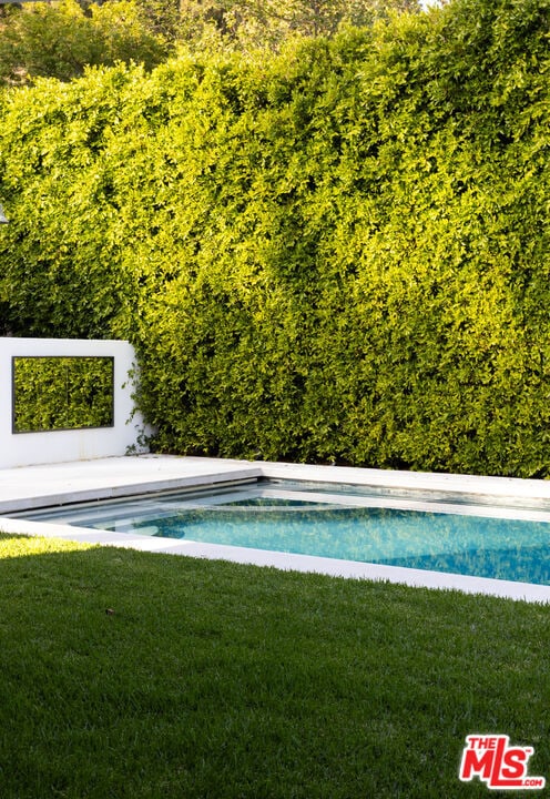 view of swimming pool featuring a lawn