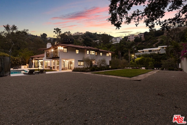 view of front of house featuring a balcony and a patio