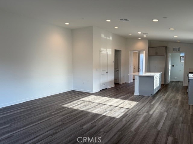interior space with light countertops, visible vents, dark wood-style flooring, and vaulted ceiling