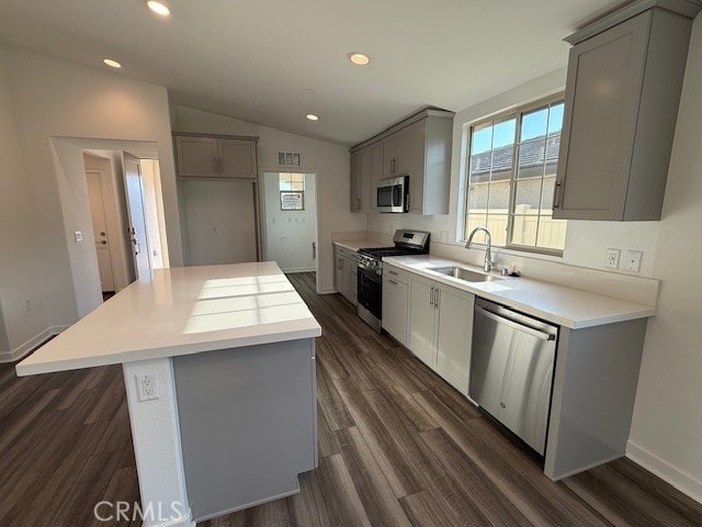 kitchen with visible vents, gray cabinetry, a sink, stainless steel appliances, and vaulted ceiling