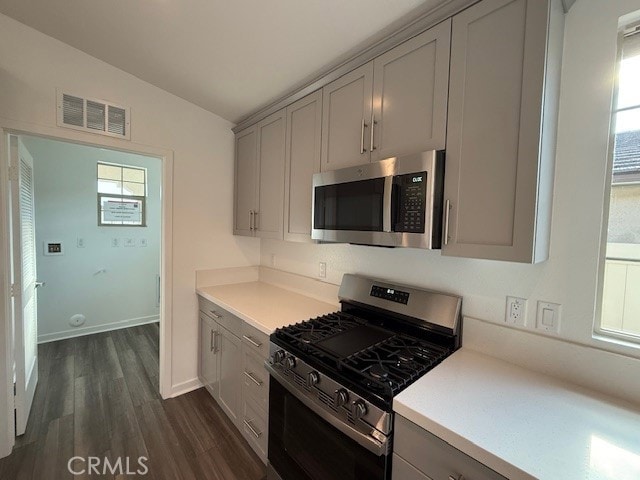 kitchen with visible vents, light countertops, lofted ceiling, gray cabinets, and stainless steel appliances