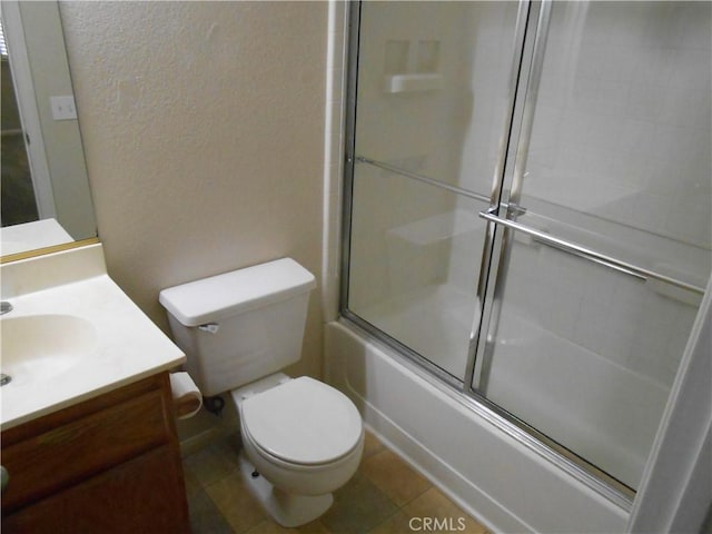 full bathroom with tile patterned flooring, vanity, combined bath / shower with glass door, and toilet