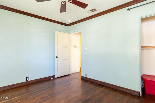 empty room with ceiling fan, dark hardwood / wood-style flooring, and crown molding