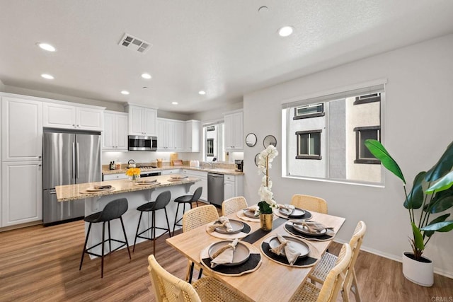 dining room with sink and light hardwood / wood-style flooring