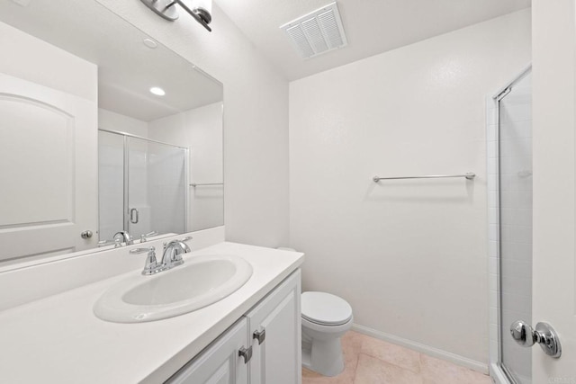 bathroom with a shower with shower door, vanity, tile patterned flooring, and toilet