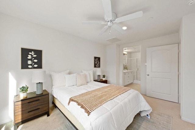 carpeted bedroom with ensuite bath and ceiling fan