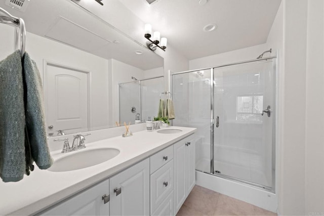 bathroom featuring a shower with shower door, vanity, and tile patterned floors