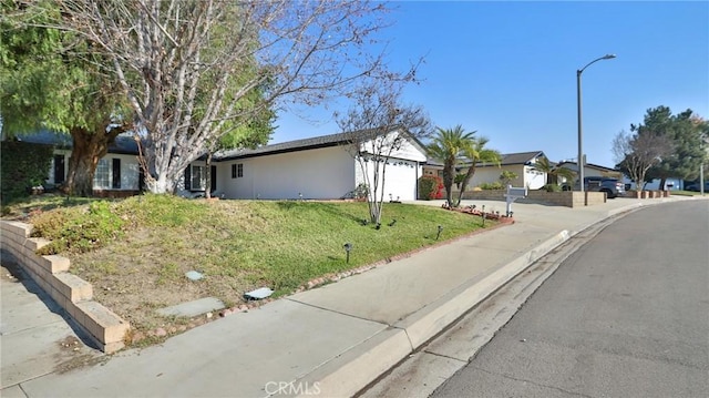 ranch-style home featuring a front yard and a garage