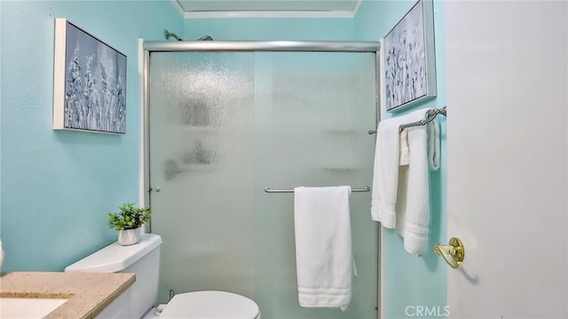 bathroom featuring toilet, vanity, an enclosed shower, and ornamental molding