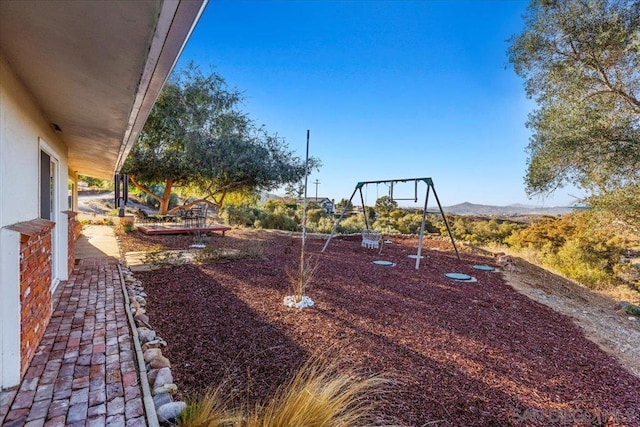 view of yard featuring a mountain view and a playground