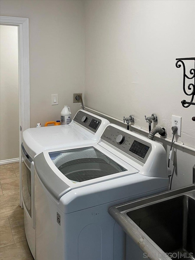 laundry area featuring washer and dryer and light tile patterned floors