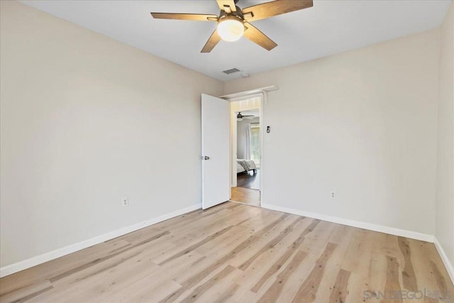 spare room with ceiling fan and light wood-type flooring