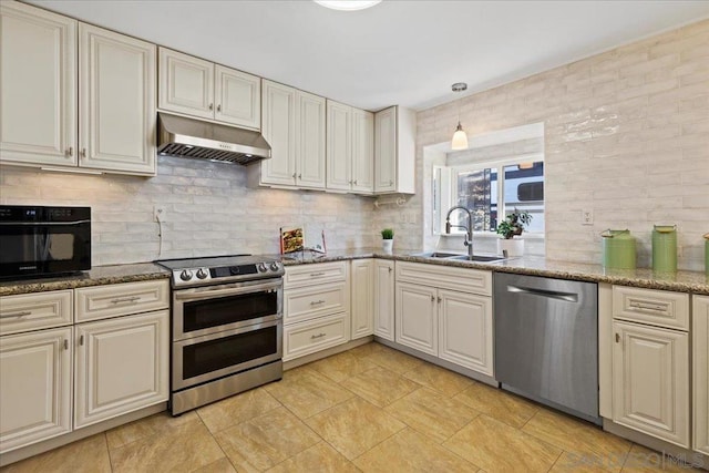 kitchen featuring decorative backsplash, sink, stainless steel appliances, and dark stone counters