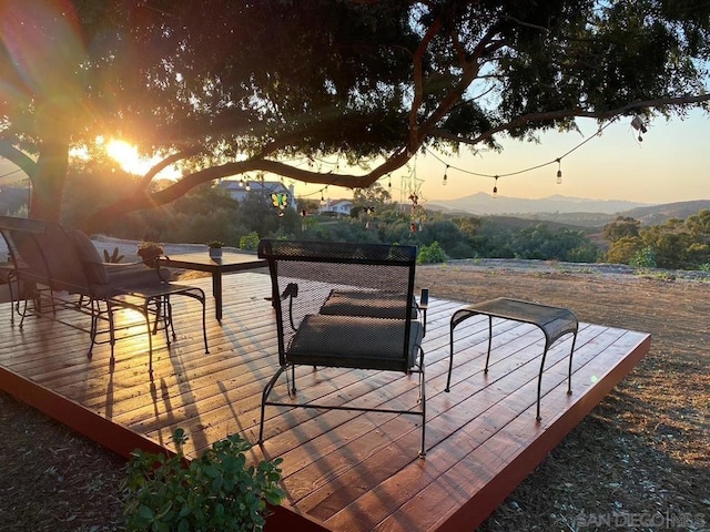 deck at dusk featuring a mountain view