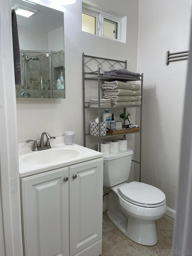 bathroom with vanity, a shower with shower door, toilet, and tile patterned flooring