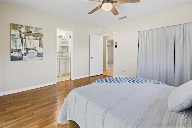 bedroom with ceiling fan, sink, wood-type flooring, and ensuite bathroom