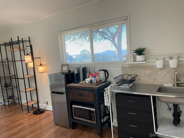 office space featuring sink, hardwood / wood-style floors, ornamental molding, and a healthy amount of sunlight