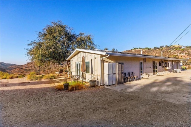 view of property exterior featuring a mountain view and a patio