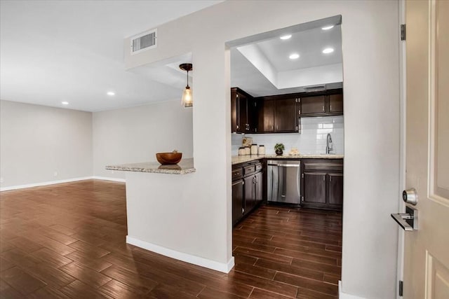 kitchen featuring decorative light fixtures, dishwasher, sink, dark brown cabinetry, and light stone countertops