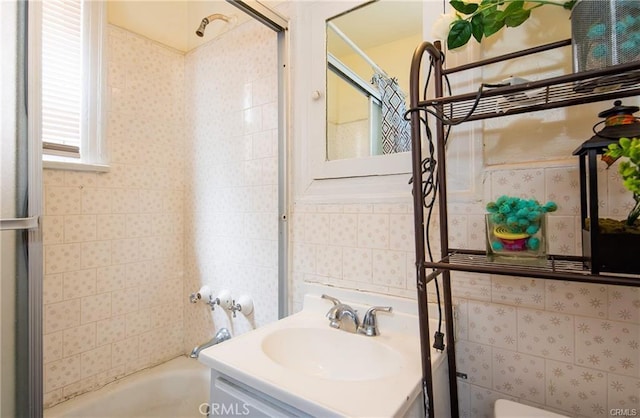 bathroom featuring tile walls, vanity, and bathing tub / shower combination