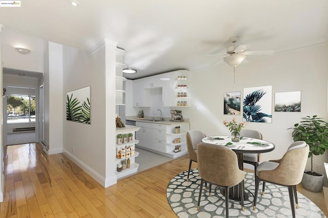 dining room featuring light hardwood / wood-style floors, sink, crown molding, and ceiling fan