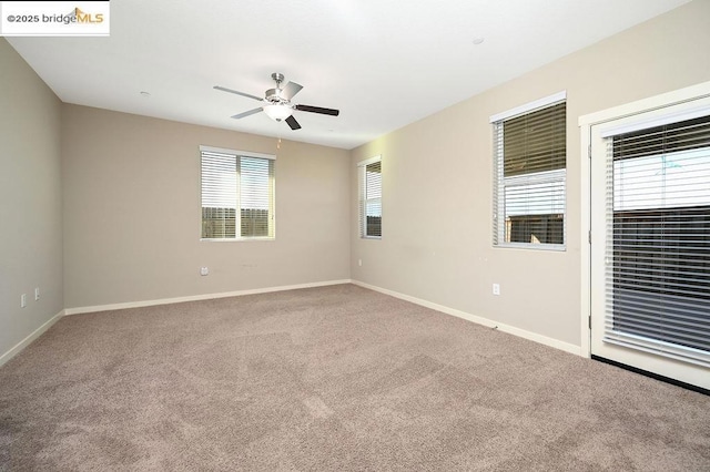 carpeted spare room with ceiling fan and a healthy amount of sunlight