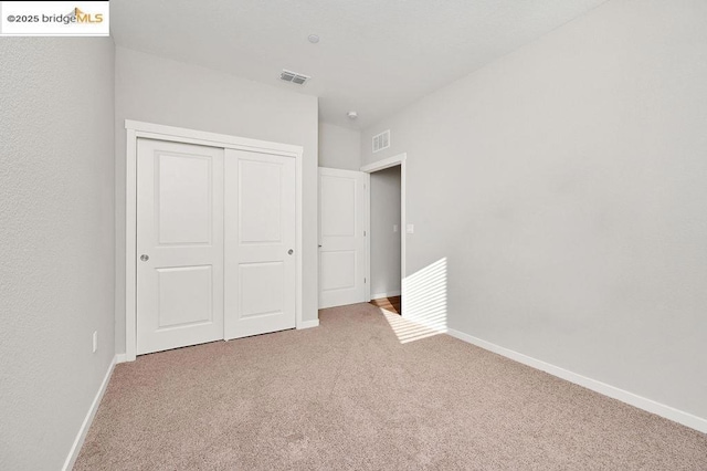 unfurnished bedroom with a closet and carpet flooring