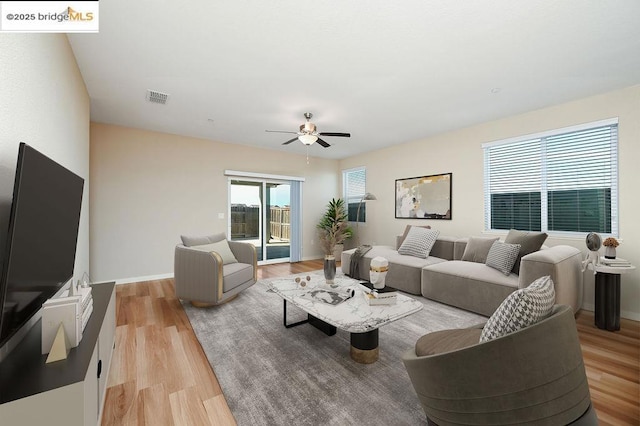 living room featuring light wood-type flooring and ceiling fan