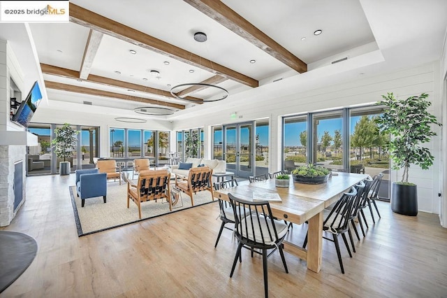 dining area featuring light hardwood / wood-style flooring and beam ceiling