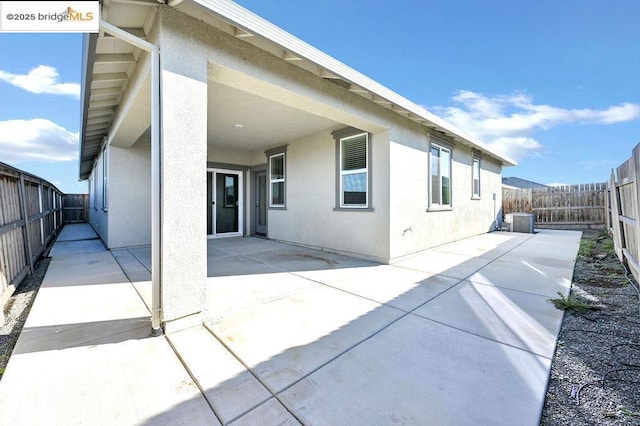 back of house with central air condition unit and a patio