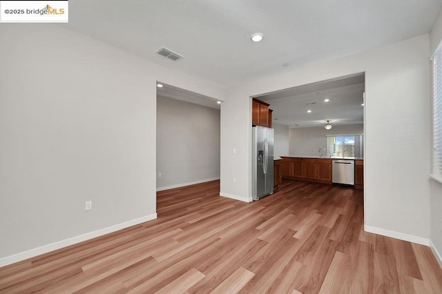 unfurnished living room featuring light hardwood / wood-style floors and sink