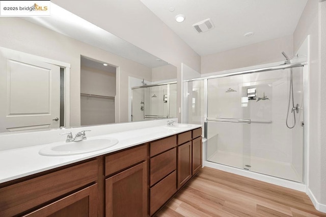 bathroom featuring a shower with door, hardwood / wood-style flooring, and vanity