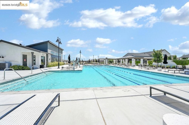 view of pool with central AC unit and a patio