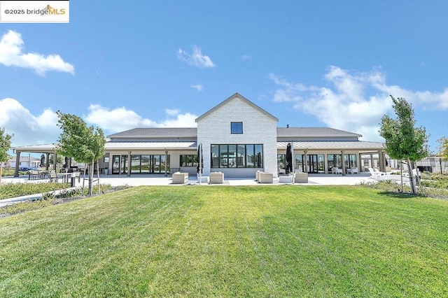 back of property featuring a lawn and a patio