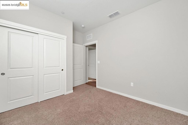 unfurnished bedroom with a closet and carpet flooring