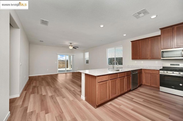 kitchen with ceiling fan, range, light hardwood / wood-style flooring, and sink