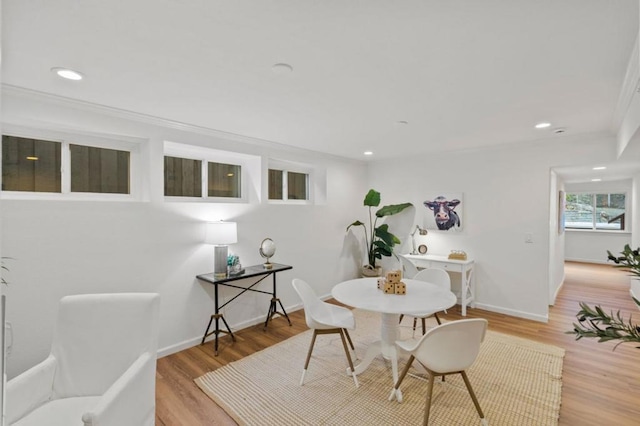 dining area with light hardwood / wood-style floors and crown molding